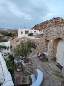 ein Steingebäude mit einem Tisch und Stühlen im Hof in der Unterkunft Artemis cottage in Super Paradise Beach