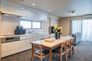 una cucina con un tavolo e alcune sedie e una cucina con un lavello di LABEL 01 Dotonbori Aparthotel ad Osaka