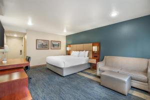 a hotel room with a bed and a couch at Best Western Plus Clocktower Inn in Billings +57 photos