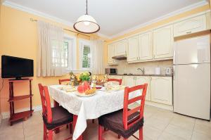 a kitchen with a table and chairs and a white refrigerator at Apartment Iva in Omiš +28 photos