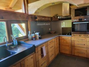 een keuken met houten kasten en een spoelbak bij Chalet Chamois & Spa in Lullin +12 foto's