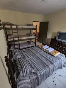 a bedroom with a bed with a striped blanket at Hospedaria Allecrim in Santo André