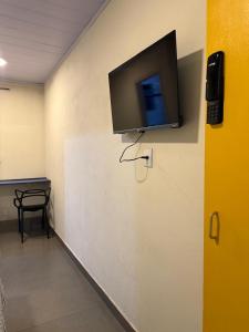 a flat screen tv on a wall in a room at Suíte Céu in Congonhas +8 photos