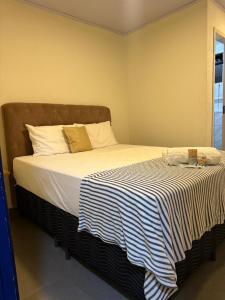 a bedroom with a large bed with a striped blanket at Suíte Céu in Congonhas