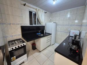 弗洛里亚诺波利斯Studio próximo ao Shopping Floripa的带炉灶和冰箱的小厨房