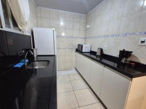 弗洛里亚诺波利斯Studio próximo ao Shopping Floripa的带冰箱和水槽的小厨房