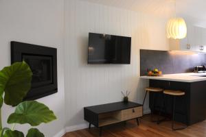 un soggiorno con cucina e TV a parete di Hideaway Falls - Bunya Cottage a Mapleton Altre 10 foto
