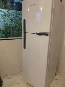 a white refrigerator in a kitchen with a window at Luxury caiçara house in Paraty in Paraty +19 photos