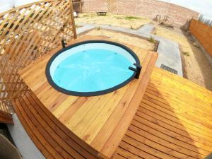 a circular pool on a wooden deck with a wooden deck at Andinas de Uco Lodge in La Consulta