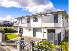 a white house with a fence in front of it at Smith House in Whanganui