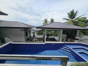 a swimming pool with blue tiles on the side of a house at Eagles Nest Beach Resort Room 4 in Samal
