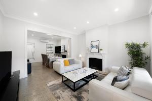 Elle comprend un salon doté d'un mobilier blanc et d'une cheminée. dans l'établissement Jam Home City Urban Oasis Darlinghurst Terrace, à Sydney