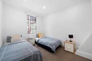 une chambre avec deux lits et une fenêtre dans l'établissement Jam Home City Urban Oasis Darlinghurst Terrace, à Sydney