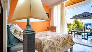 a bedroom with a bed and a table with an umbrella at casa del mar in San Rafael del Sur +10 photos
