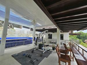 a gym with treadmills and exercise equipment on a balcony at Eagles Nest Beach Resort Room 5 in Samal
