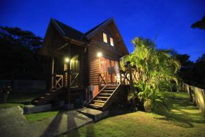 a small house with a staircase leading up to it at night at Tokashiki Guest House in Tokashiki