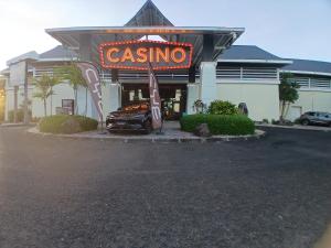 a casino sign with a car in front of a building at Studio Sucre de Canne - Résidence calme avec plage et piscine privées in Saint-François