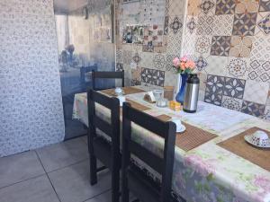 a table with two chairs and a table with flowers on it at Hostel Mi Casa Su Casa 1 in Poços de Caldas +6 photos