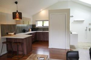 an open kitchen with a counter and a table at Hideaway Falls - Piccabeen Cabin in Mapleton