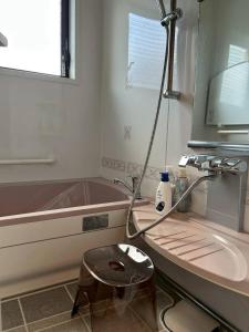 郡上市にあるRiver front Guest House 風の洗面台、浴槽、椅子を備えたバスルーム