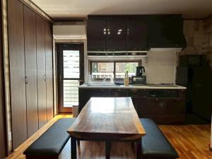 a kitchen with a wooden table in the middle at River front Guest House 風 in Gujo