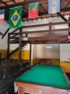 a pool table in a room with flags on the ceiling at Meu Aconchego Casa Duplex com Piscina e Salão de jogos, 400mt da Praia in Arraial do Cabo