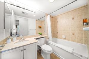 La salle de bains est pourvue de toilettes, d'un lavabo et d'une baignoire. dans l'établissement Chic 1BR Downtown Getaway w King Bed, à Toronto