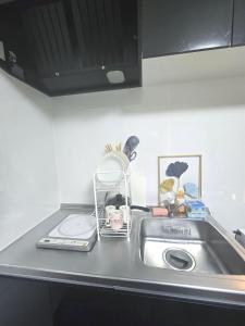 a kitchen sink with a dish rack next to it at 通天閣徒歩1分3ベッド in Osaka