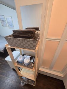 a basket of towels on a shelf in a room at 通天閣徒歩1分3ベッド in Osaka