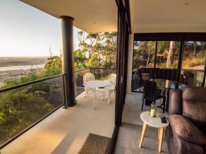 a room with a balcony with a table and chairs at Sheer Pleasure Accommodation in Smithton