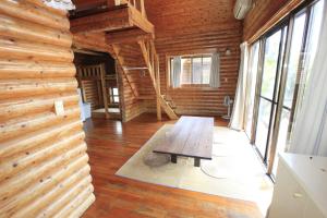 a wooden room with a table in the middle of it at Tokashiki Guest House in Tokashiki
