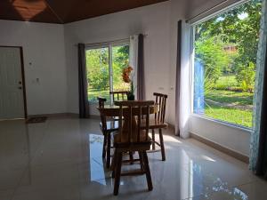 a dining room with a table and chairs and a window at Taw K'a Cabañas 