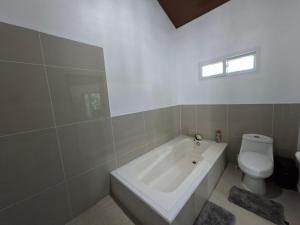 a bathroom with a white tub and a toilet at Taw K'a Cabañas 