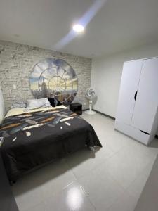 a bedroom with a bed and a painting on the wall at La Casa Amarilla in Medellín