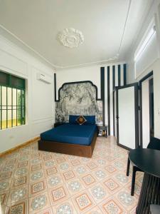 ein Schlafzimmer mit einem blauen Bett und einem Tisch in der Unterkunft MoonNest vila catba in Cát Bà