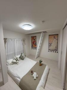 ein weißes Schlafzimmer mit einem Bett und einer Treppe in der Unterkunft Sogno House Tokyo Ueno in Tokio