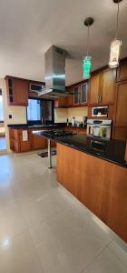 eine große Küche mit Holzschränken und einer Arbeitsplatte in der Unterkunft Hermosa y Elegante casa en Alto Barinas en alquiler in Barinas