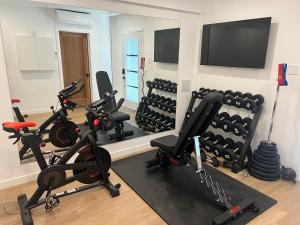 een sportschool met loopbanden en hometrainers in een kamer bij Garden Suite with Pool and Sauna in Brampton