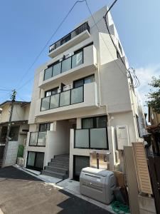 a tall white building with a appliance in front of it at さくら旅館高円寺北千利休201号室 in Tokyo