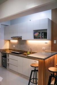 a kitchen with white cabinets and a counter with stools at Urban Chic Home Urban Chic Home with balcony in Pajo