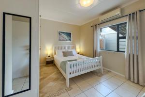 a bedroom with a white bed and a window at Central Modern 2 Bedroom - Bergrivier Hideaway in Velddrif