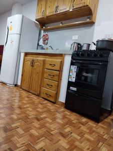 a kitchen with a black stove and a refrigerator at Complejo GARUPÁ in Garupá +12 photos