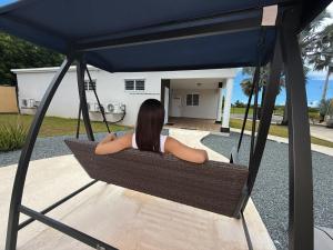 a woman sitting in a hammock under a blue canopy at LaPlaya in Manati +2 photos