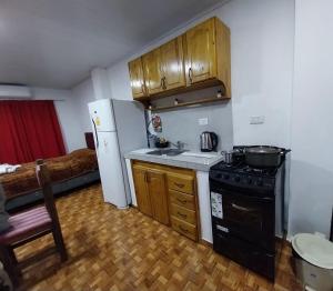 a kitchen with a refrigerator and a sink and a stove at Complejo GARUPÁ in Garupá