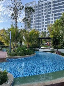 a large blue swimming pool in front of a large building at Gamuda Sky Luge Faiz Homestay in Rawang