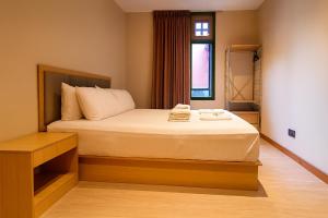 a bedroom with a bed and a window at Wink at Upper Cross Street in Singapore