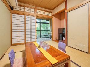 a dining room with a wooden table and chairs at Oyado Yumechidori in Saga
