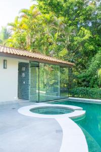 a house with a swimming pool next to a house at Villa Entre Verdes in Riviera de São Lourenço
