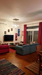 un salon avec un canapé et une télévision dans l'établissement Villa 4 Bedrooms Marassi Verdi, à El Alamein