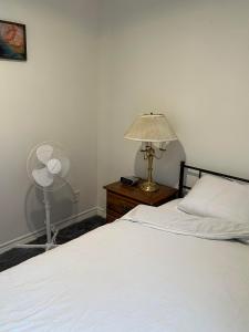 a bedroom with a bed and a lamp and a fan at Goldwin's Place in Toronto +18 photos